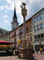 Pestsäule am Hauptplatz met op de achtergrond de Stadtpfarrkirche